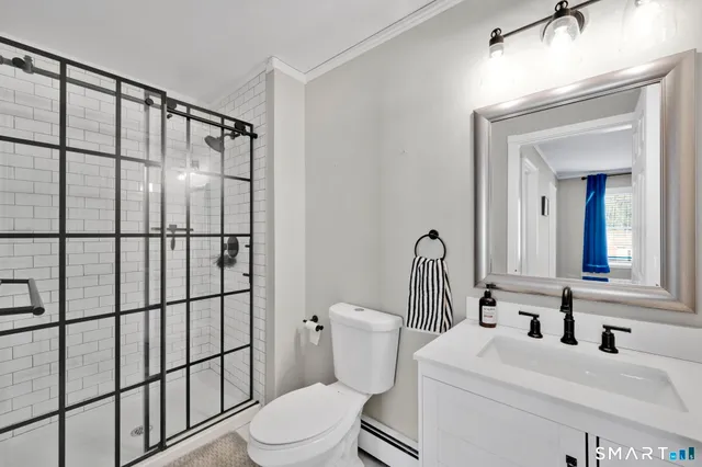 a bathroom with a sink a toilet and shower