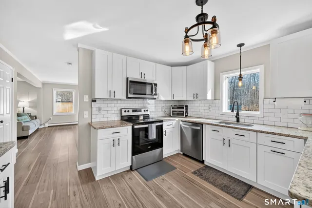 a kitchen with cabinets a sink and stainless steel appliances