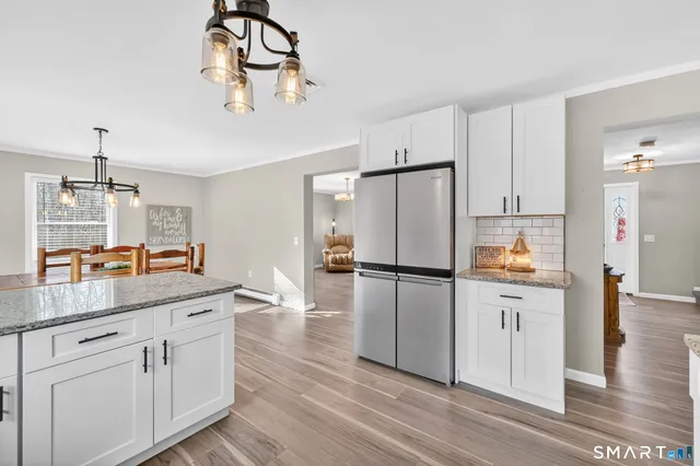 a kitchen with kitchen island white cabinets and stainless steel appliances