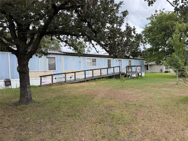 a view of a house with backyard and trees