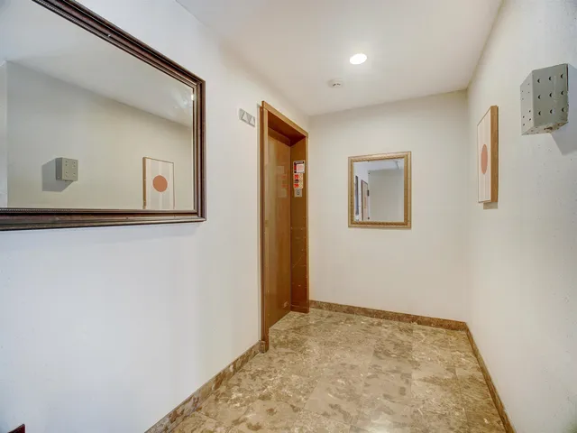 a view of a hallway with bathroom and wooden floor