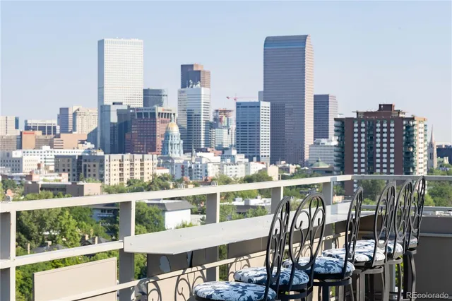 a balcony with city view and tall trees