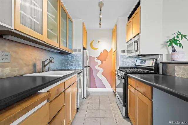 a kitchen with stainless steel appliances granite countertop a sink and a stove
