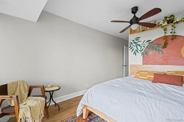 a bedroom with a bed and a painting on the wall