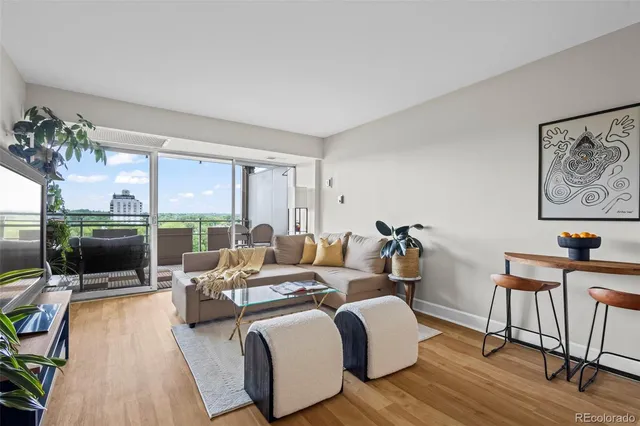 a living room with furniture a flat screen tv and a floor to ceiling window