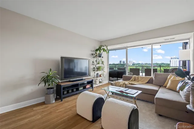 a living room with furniture large windows and a flat screen tv