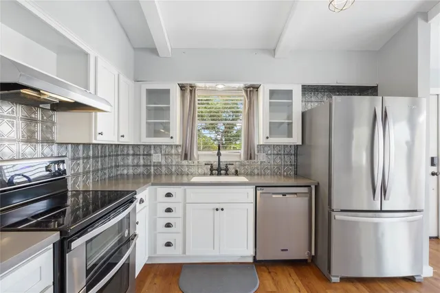 a kitchen with white cabinets and white appliances
