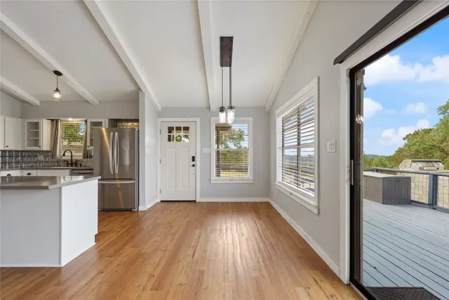 a open kitchen with wooden floors and wide window