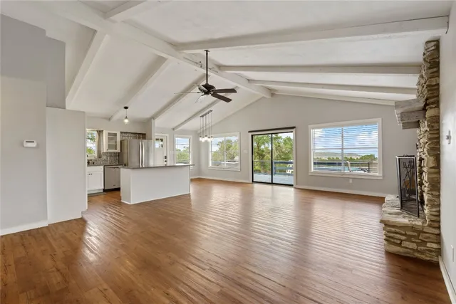 a view of empty room with wooden floor and fireplace