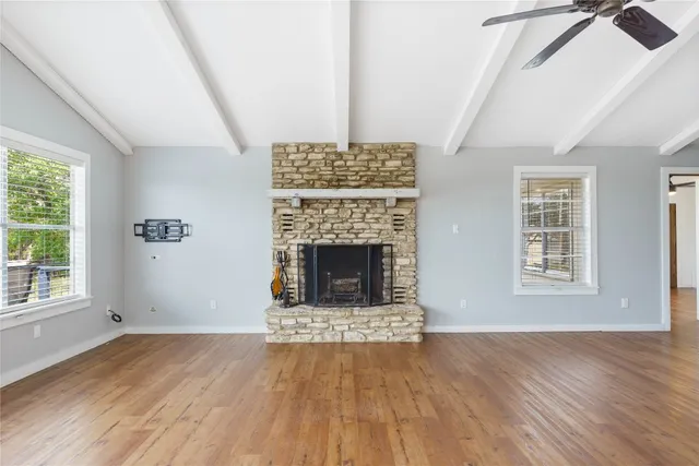 an empty room with windows and fireplace