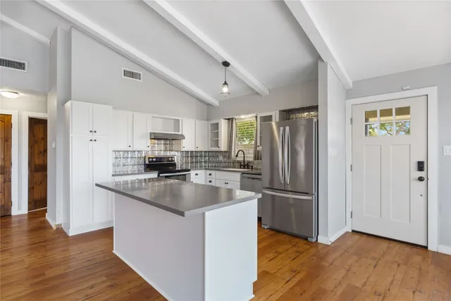 a kitchen with granite countertop a refrigerator and a sink