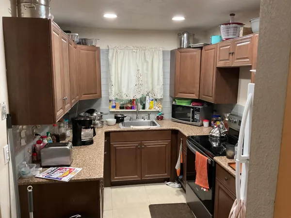 a kitchen with stainless steel appliances a sink a stove a refrigerator a sink and cabinets