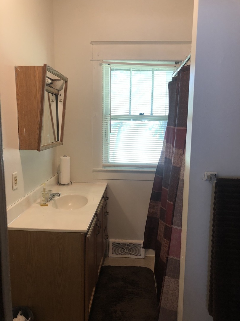 300 North Maple Street Normal, IL 61761 - Photo 11 of 18 a bathroom with a sink toilet and mirror