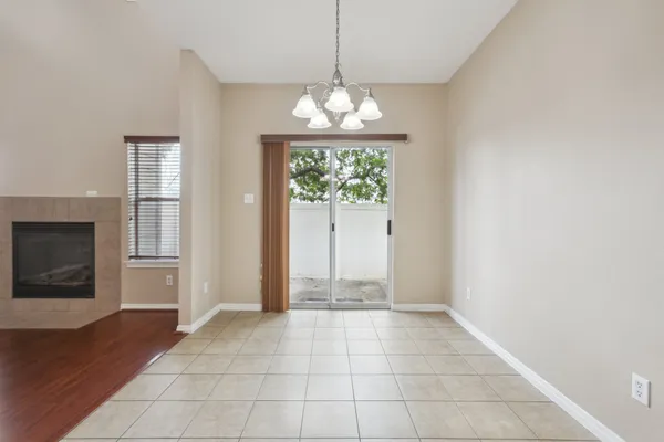 a view of an empty room with window wooden floor and a kitchen