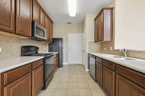a kitchen with stainless steel appliances granite countertop a sink and cabinets