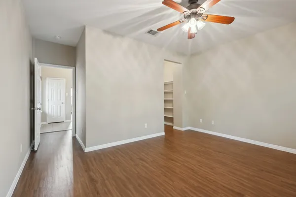a view of an empty room with wooden floor