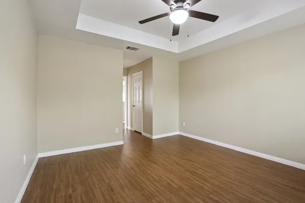 a view of an empty room with wooden floor