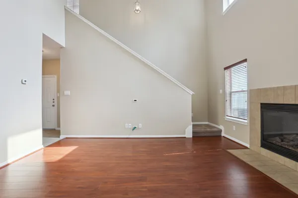 a view of a livingroom with wooden floor and a fireplace