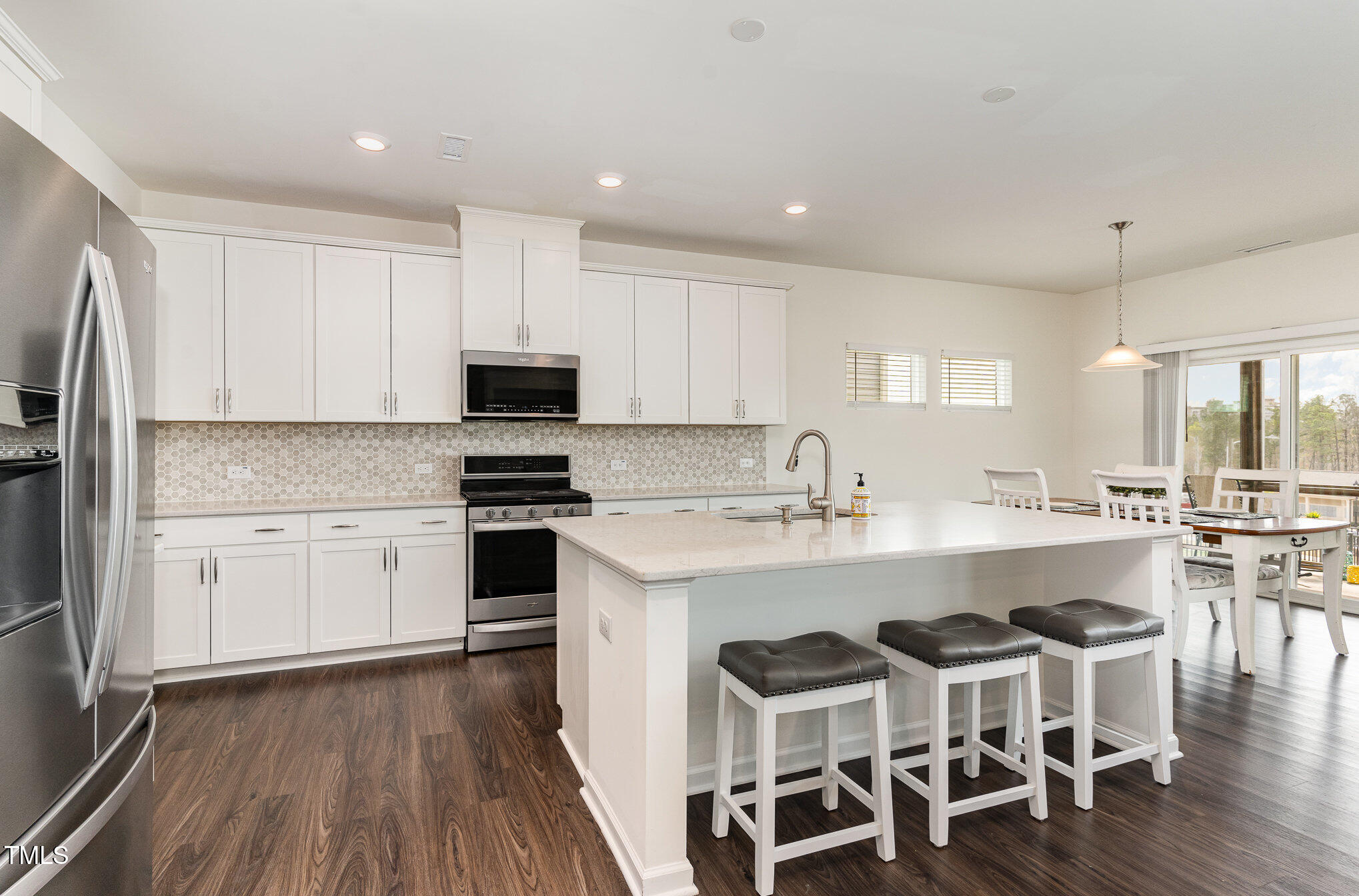 1040 Lippincott Road Durham, NC 27703 - Photo 7 of 43 a white kitchen with wooden floors and white cabinets