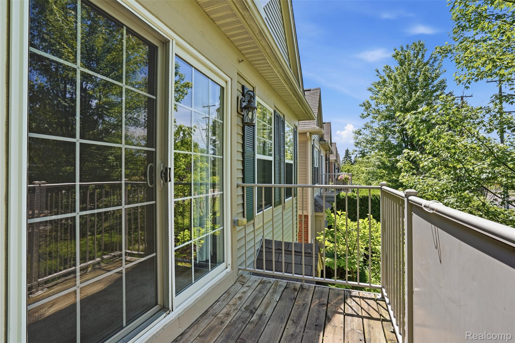 320 North Wixom Road, Unit 30 Wixom, MI 48393 - Photo 28 of 28 Exterior balcony featuring wood-finish decking, light-colored vinyl siding, and a metal railing