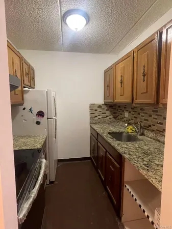 a kitchen with granite countertop a stove and a refrigerator
