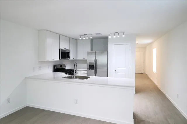 a kitchen with cabinets and stainless steel appliances