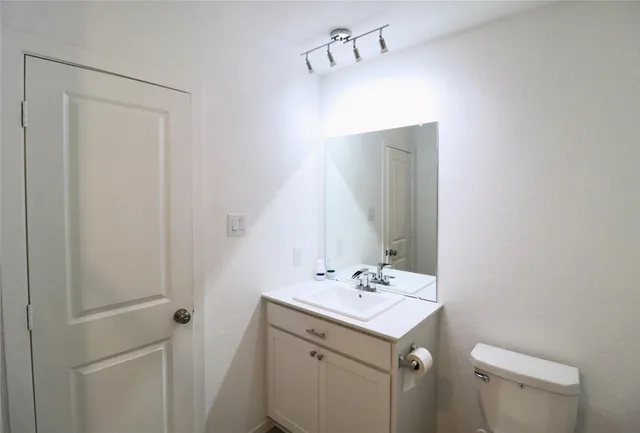 a bathroom with a sink toilet and mirror