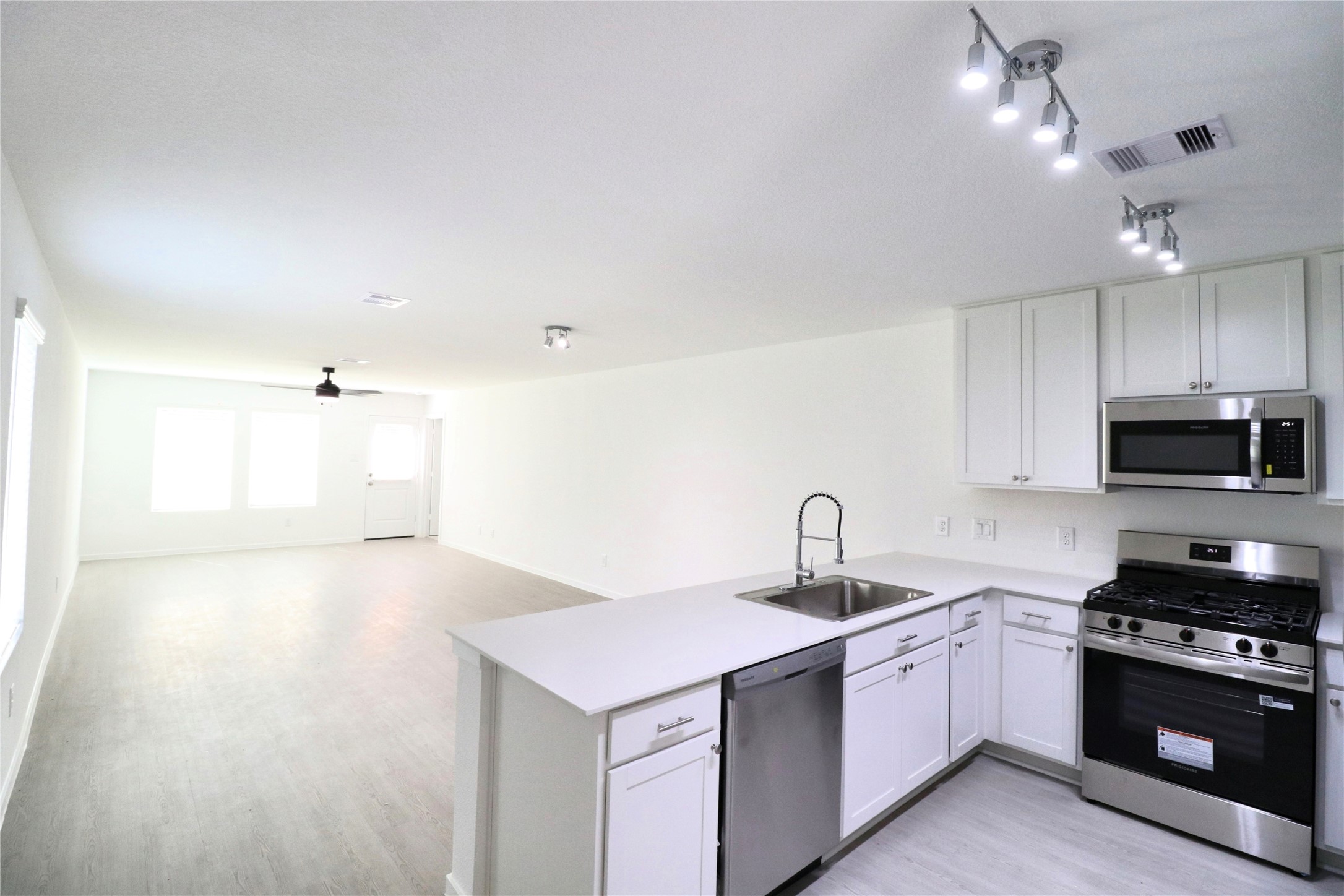 20805 Le Scifo Court New Caney, TX 77357 - Photo 9 of 20 a kitchen with kitchen island a sink stainless steel appliances and cabinets