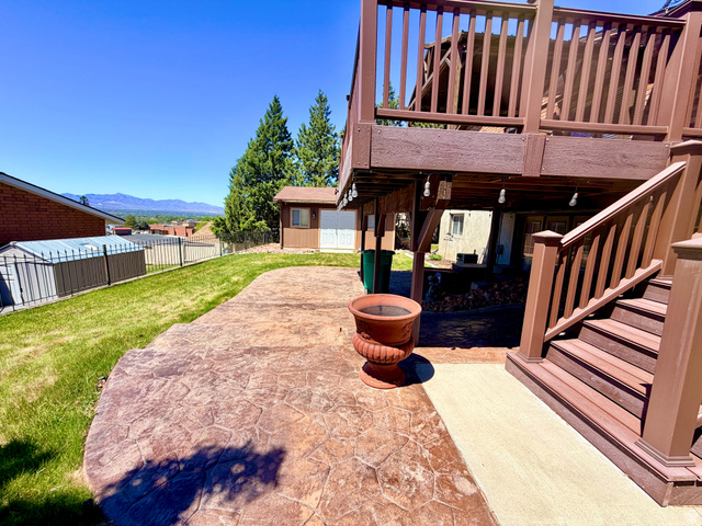 12080 Mill Ridge Circle Sandy, UT 84094 - Photo 37 of 56 Expansive stamped concrete patio with direct access to an elevated deck featuring a balustrade