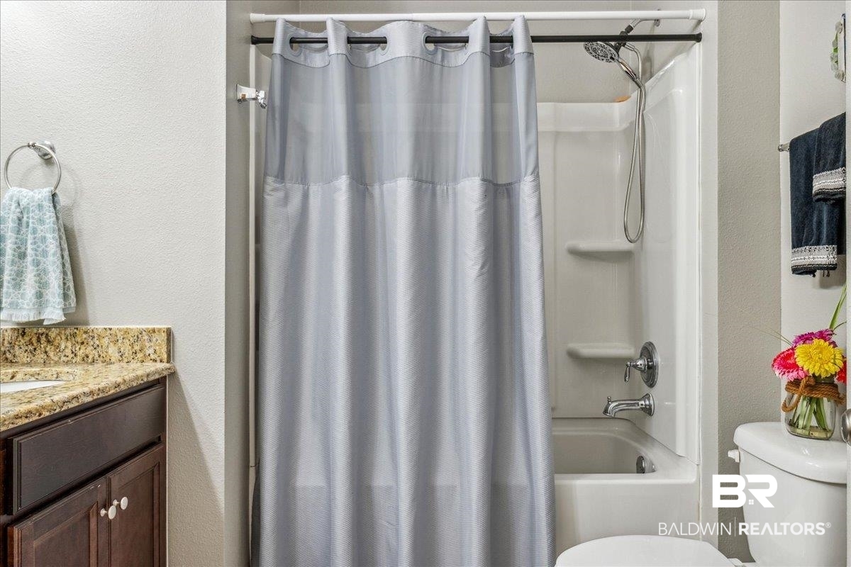 7022 Rocky Rd Loop Gulf Shores, AL 36542 - Photo 34 of 59 Bathroom featuring shower / tub combo with curtain and vanity