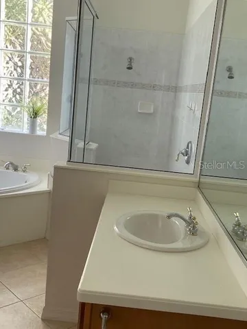 a bathroom with a granite countertop bathtub shower sink vanity and toilet