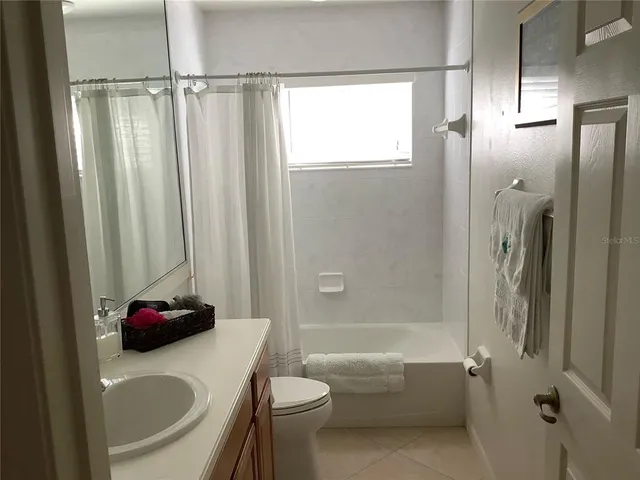 a bedroom with a bed and dresser with mirror