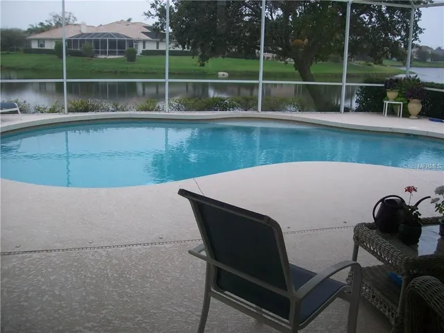 a view of a lake with a bench and trees