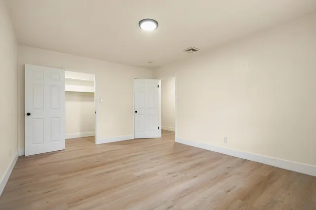 a view of an empty room with wooden floor