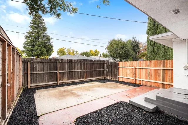 a view of backyard with wooden fence and seating