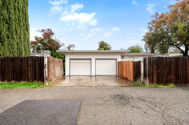 a view of backyard with small cabin and wooden fence