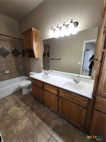 a bathroom with a double vanity sink mirror and toilet