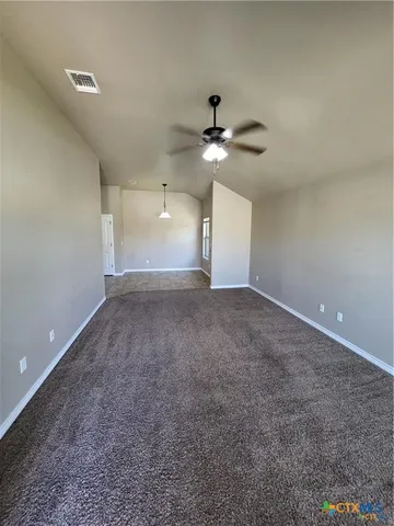 a view of an empty room with a ceiling fan