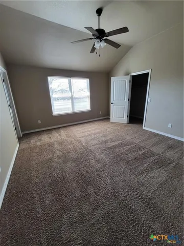 an empty room with windows and fan