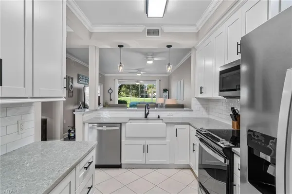 a kitchen with white cabinets and appliances