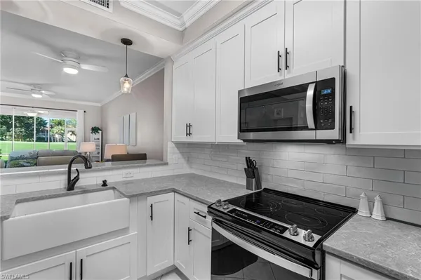 a kitchen with stainless steel appliances white cabinets and a stove top oven