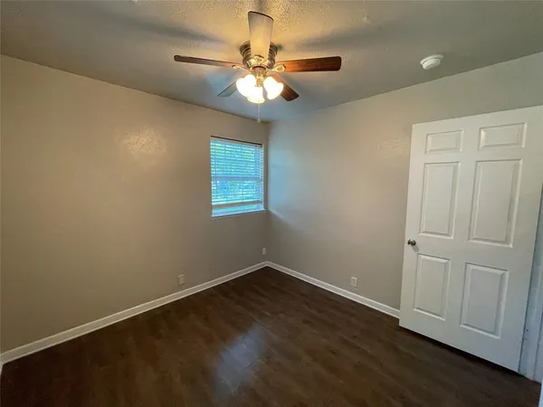 a view of a room with wooden floor and fan