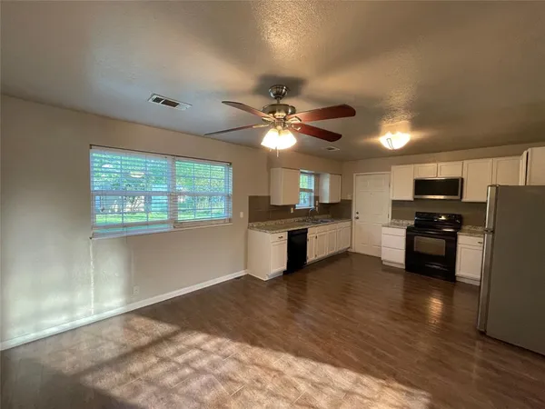 a view of kitchen with microwave and cabinets