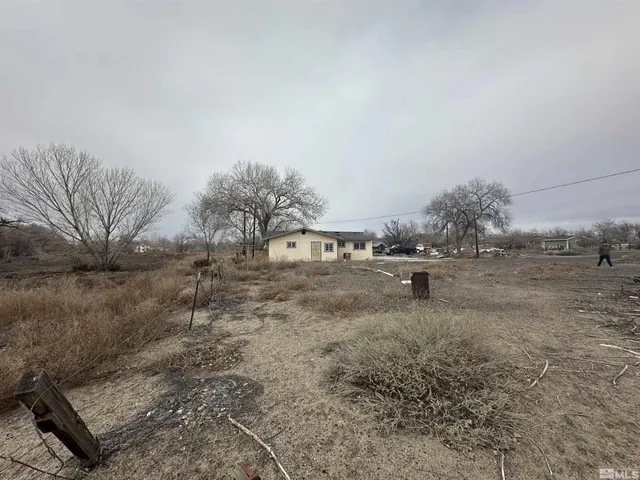 a backyard of a house with table and chairs