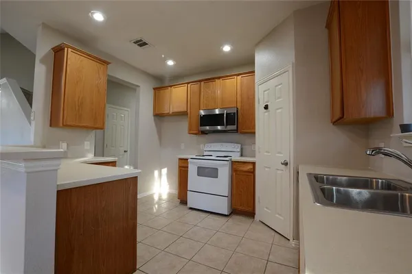 an empty room with wooden floor cabinet and windows