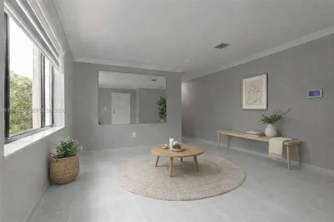 a living room with furniture a window and a potted plant