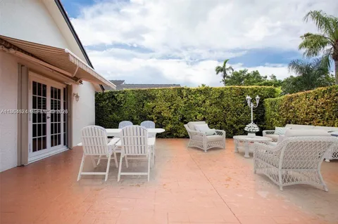 a view of a patio with couches table and chairs and potted plants