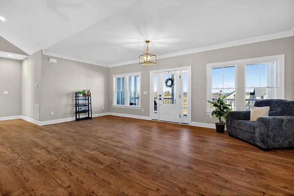 a spacious bedroom with a bed and wooden floor