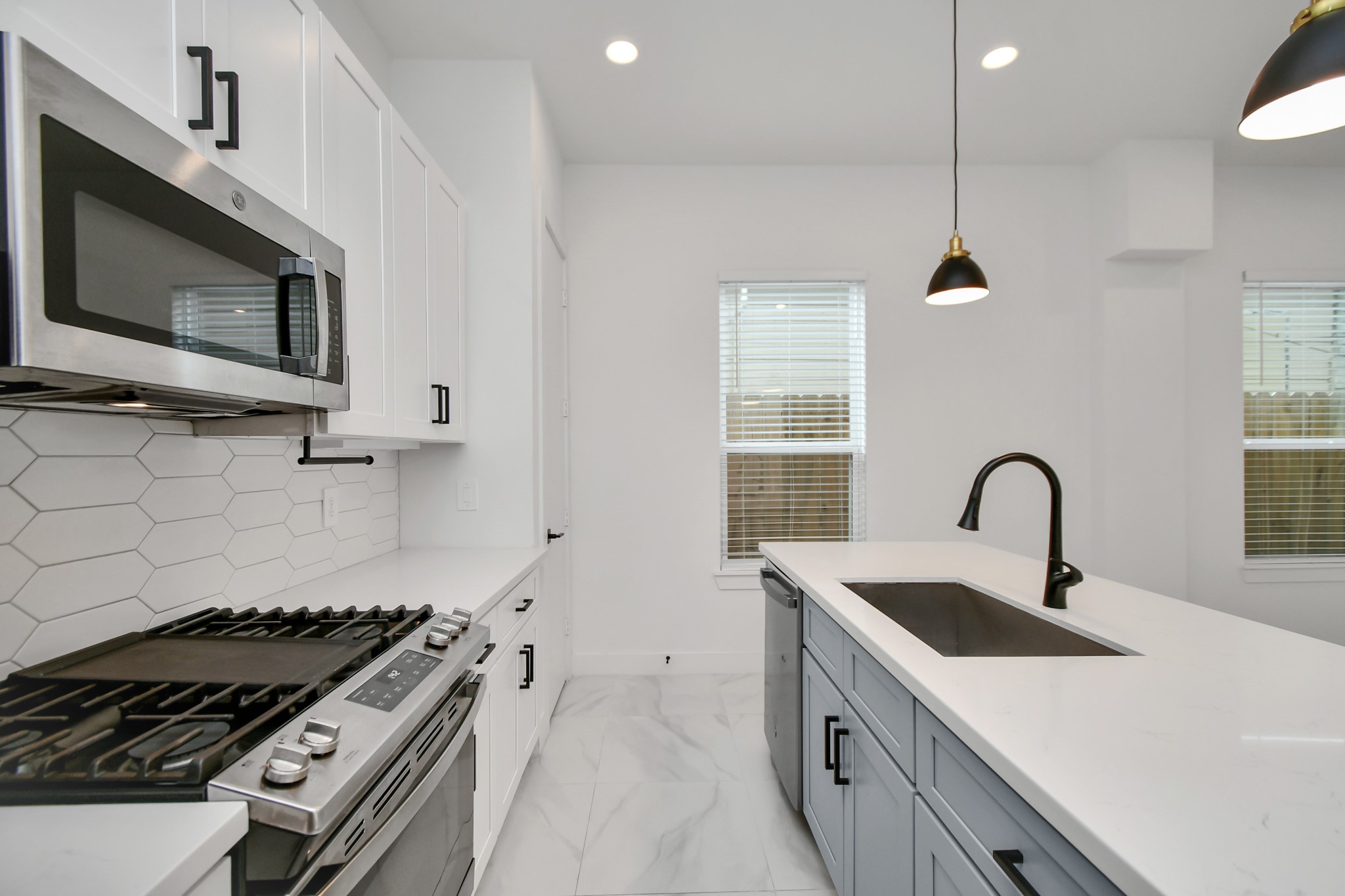 853 Mansfield Street, Unit E Houston, TX 77091 - Photo 20 of 47 a kitchen with stainless steel appliances a sink a stove and a microwave