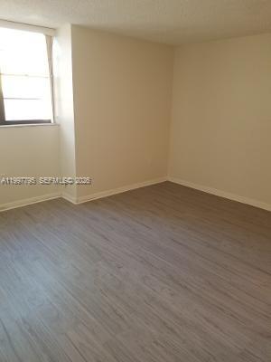 10425 Southwest 112th Avenue, Unit 211 Miami, FL 33176 - Photo 8 of 18 an empty room with wooden floor and windows